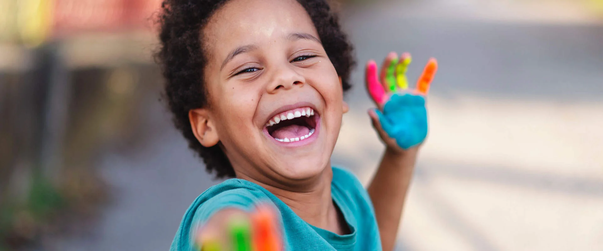 Laughing child with paint on one hand