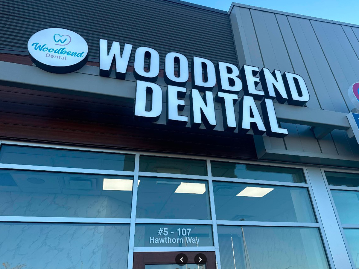 Woodbend Dental sign on the clinic building in Leduc